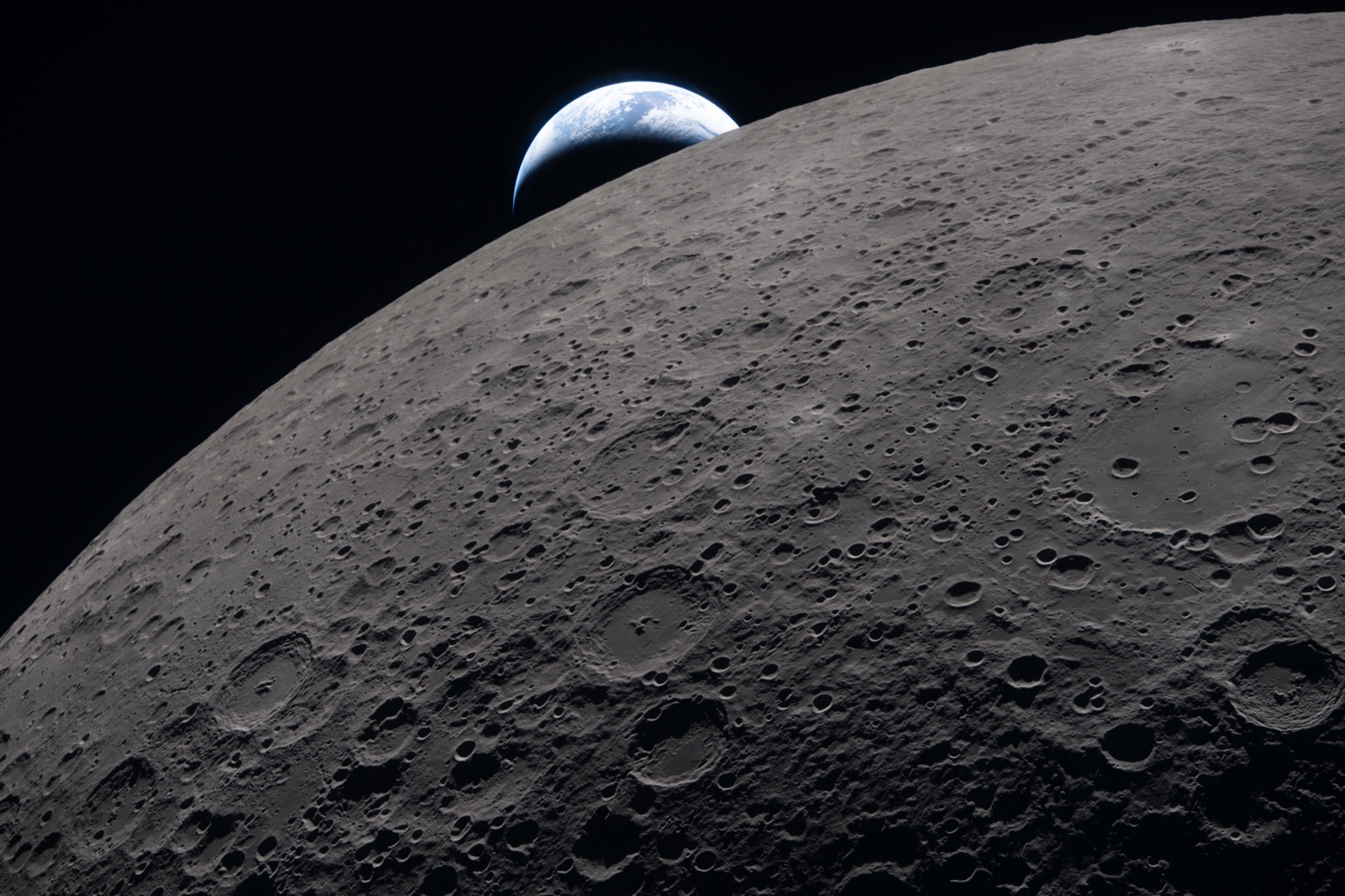 Erdaufgang: die Erde als blaue Sichel über dem Mondhorizont